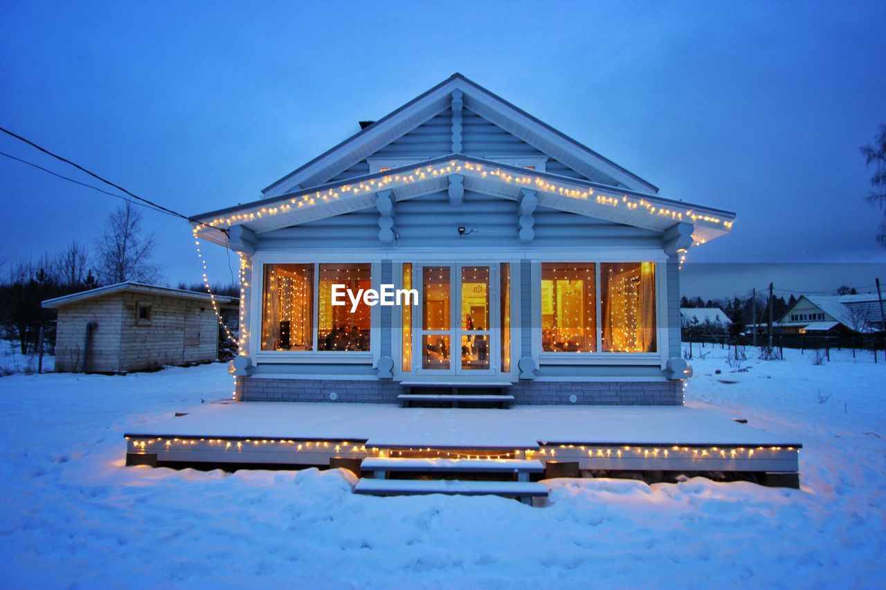 SNOW COVERED HOUSE AGAINST SKY