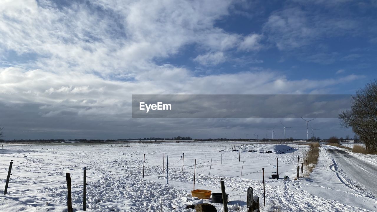 SCENIC VIEW OF SNOW COVERED LAND AGAINST CLOUDY SKY