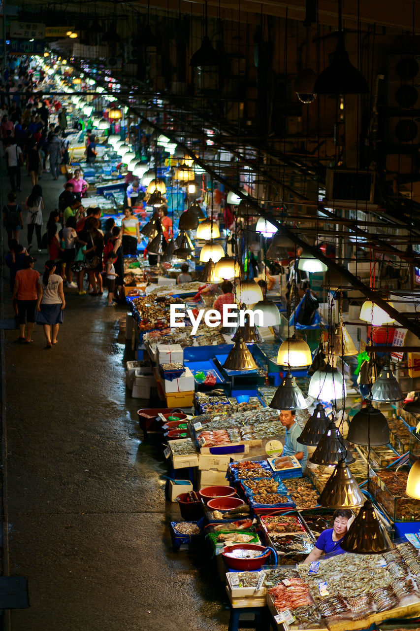 HIGH ANGLE VIEW OF ILLUMINATED MARKET FOR SALE AT STREET