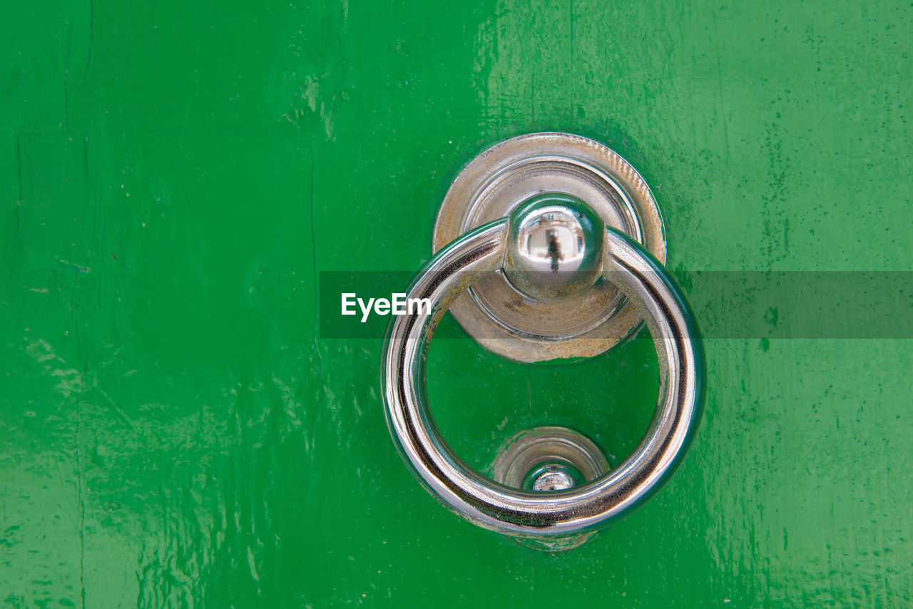 Silver door knocker on a green wooden door. mdina, malta