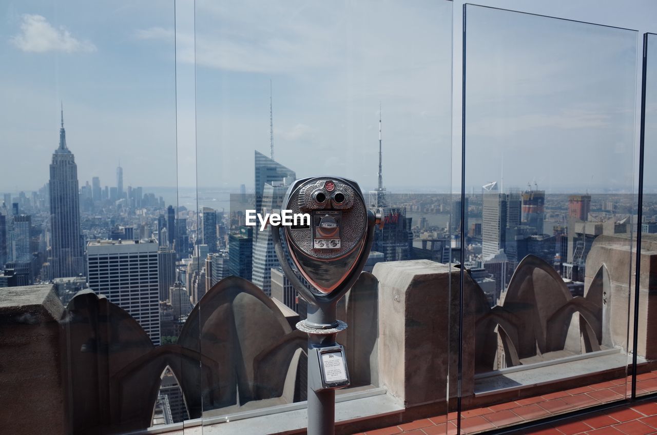 Coin-operated binoculars in building against sky