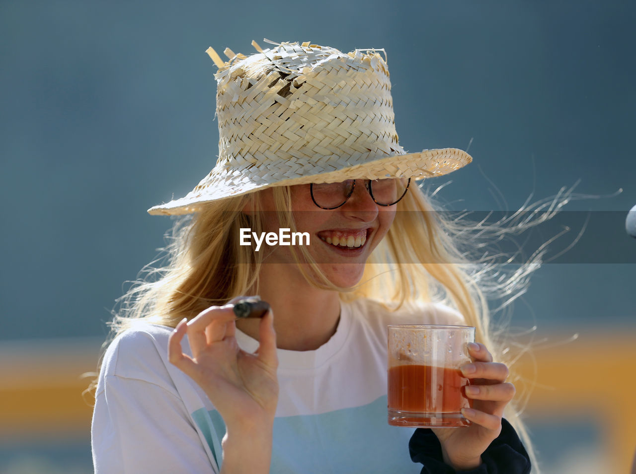 YOUNG WOMAN WEARING HAT WITH DRINK