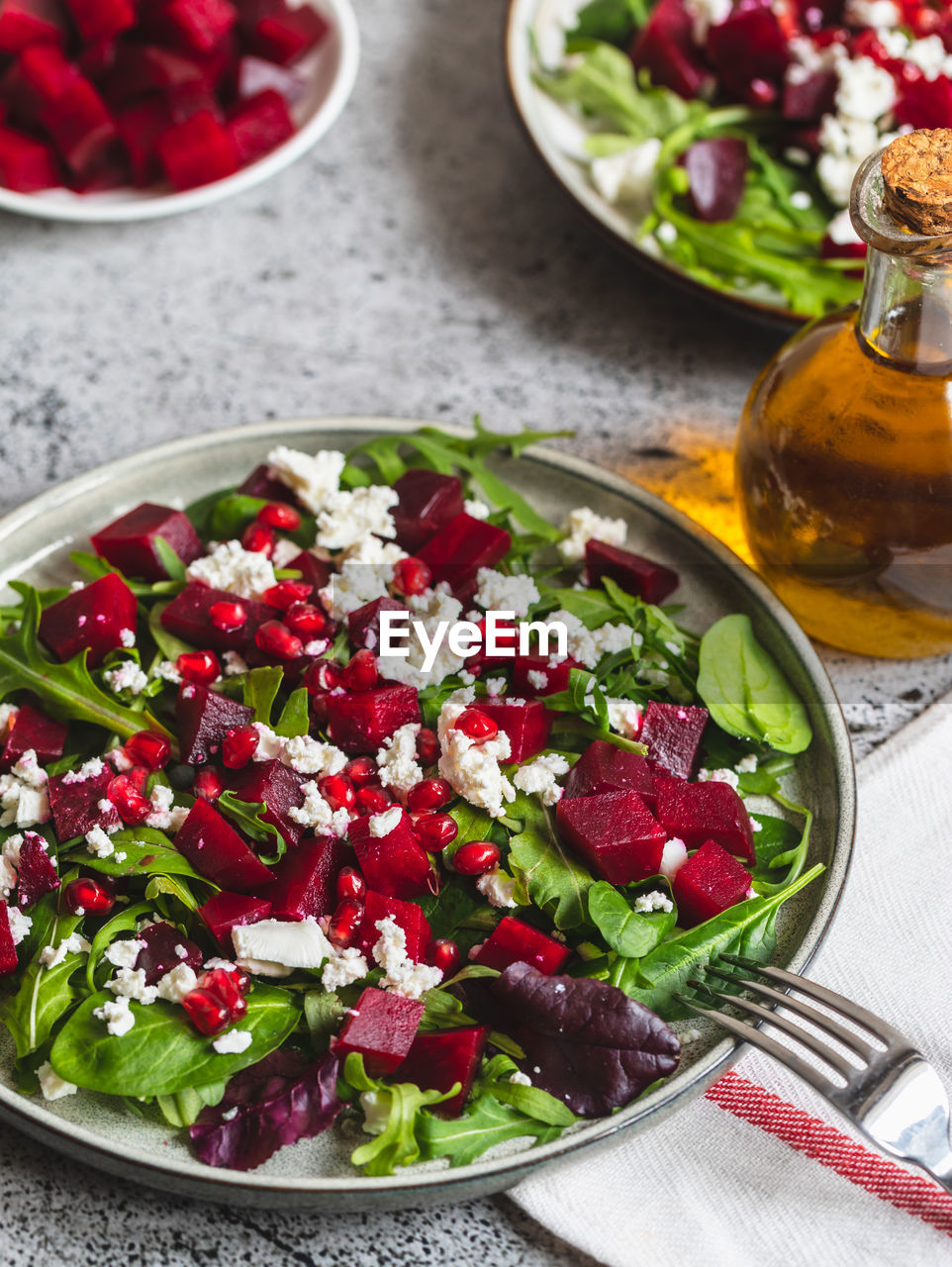 Arugula, beet and cheese salad with pomegranate and dressing on plate 