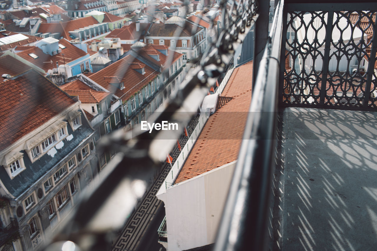 High angle view of buildings in city seen through fence