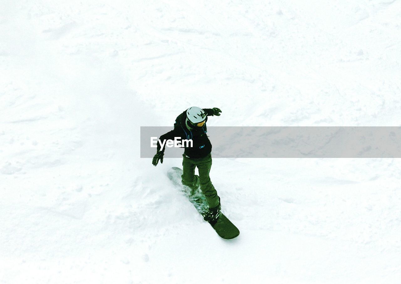 High angle view of men skateboarding on snowy field