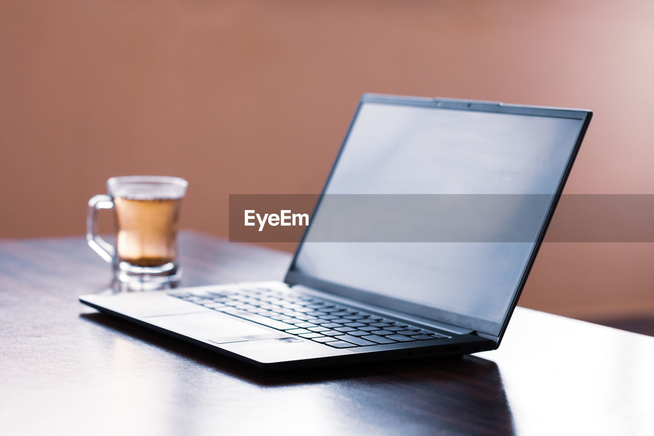 CLOSE-UP OF COFFEE CUP ON TABLE IN ROOM