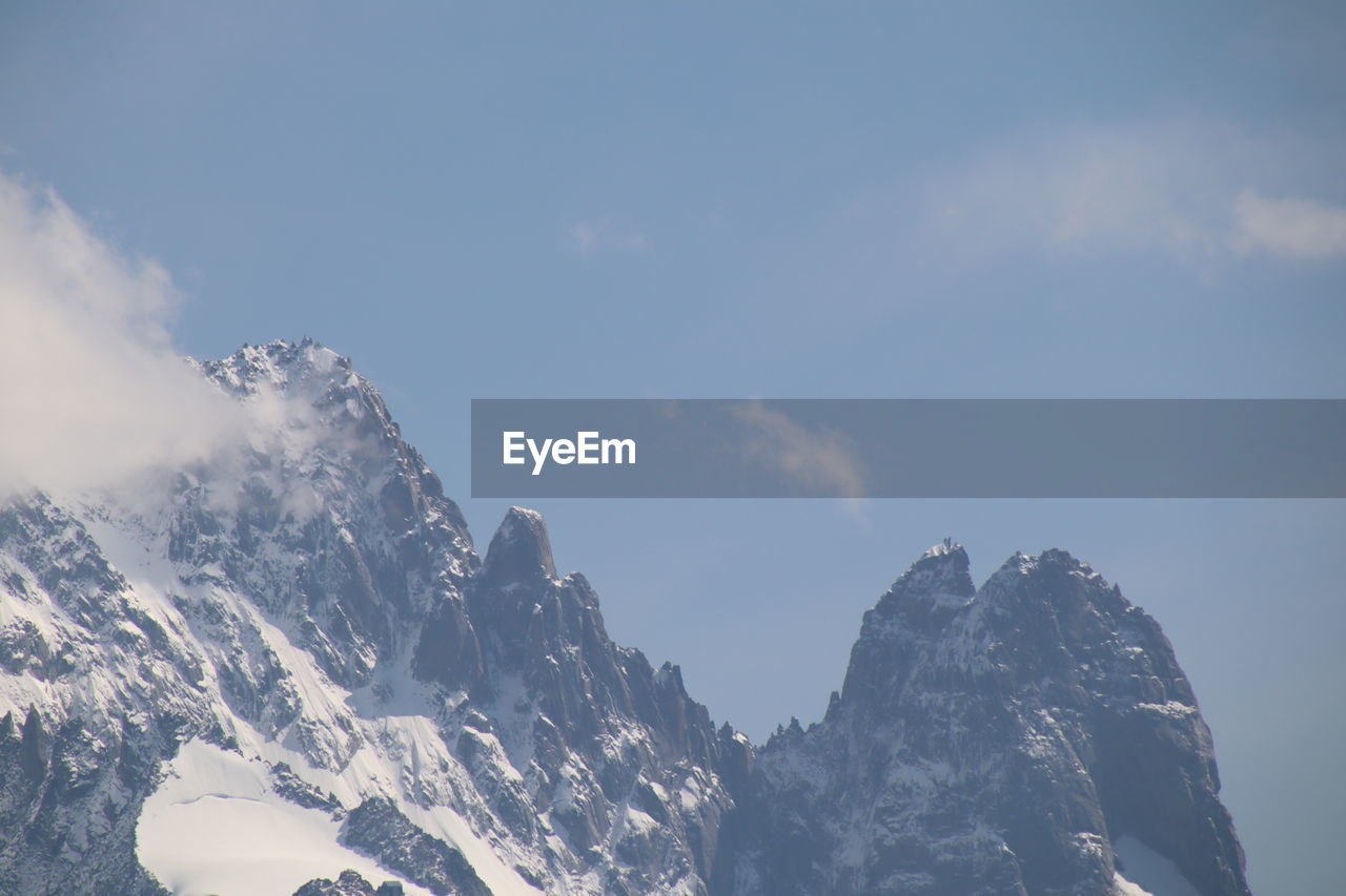 LOW ANGLE VIEW OF SNOWCAPPED MOUNTAIN RANGE AGAINST SKY