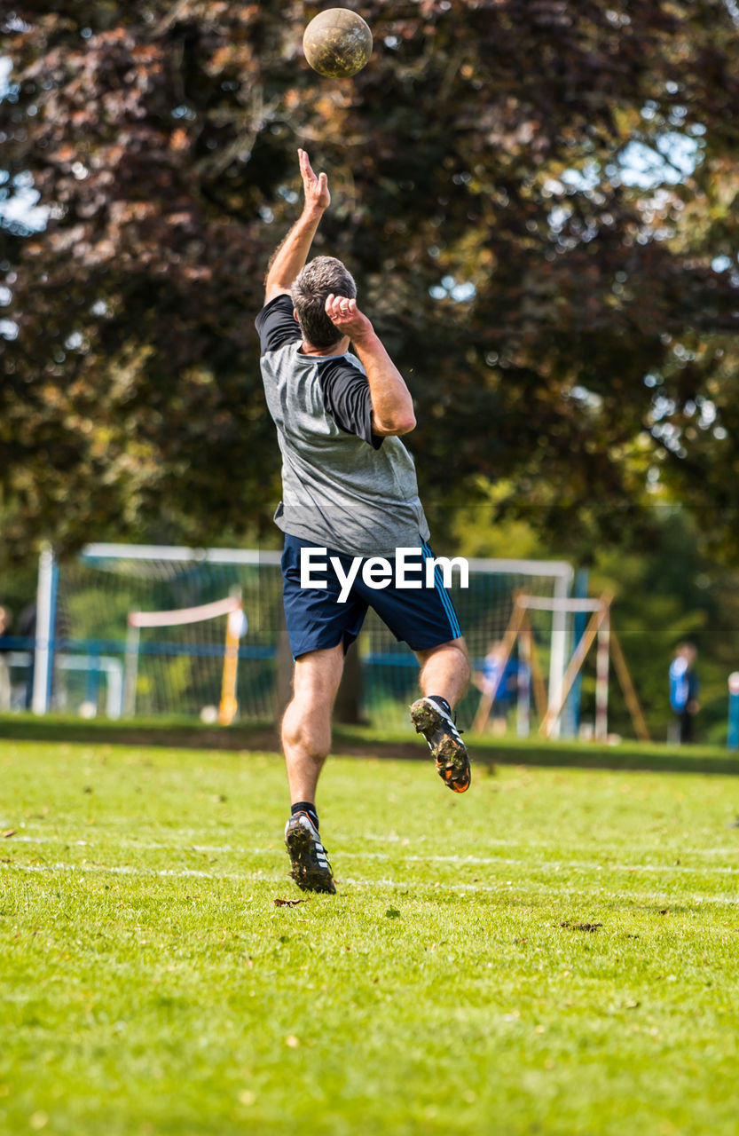 Full length of man playing soccer on field