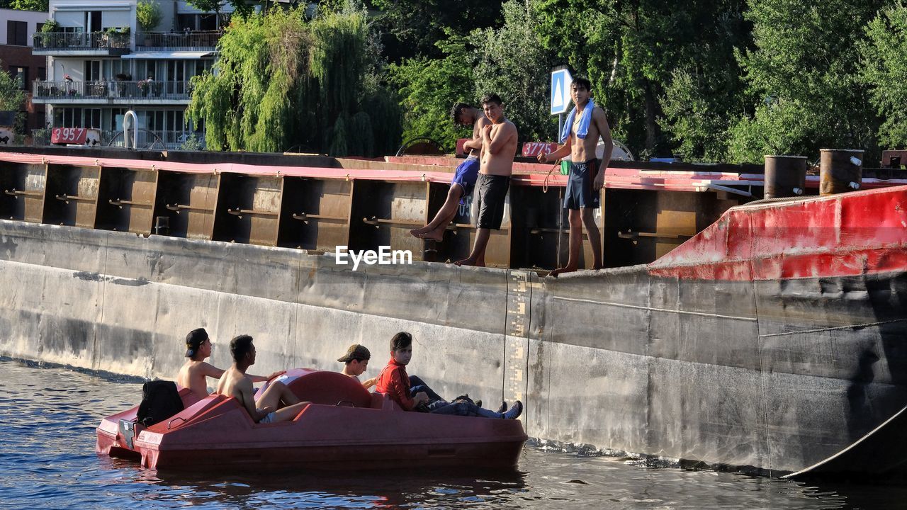 PEOPLE ON BOATS IN CANAL