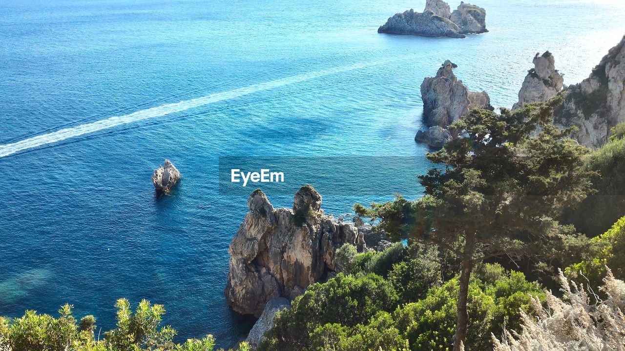 HIGH ANGLE VIEW OF ROCK FORMATIONS BY SEA