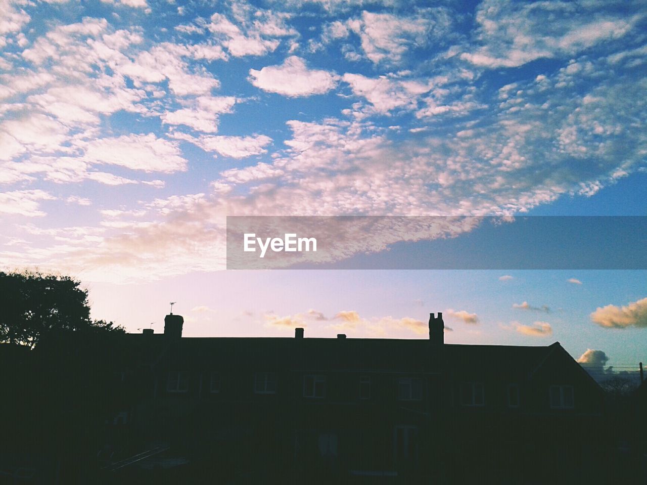 Low angle view of silhouette house against sky during sunset