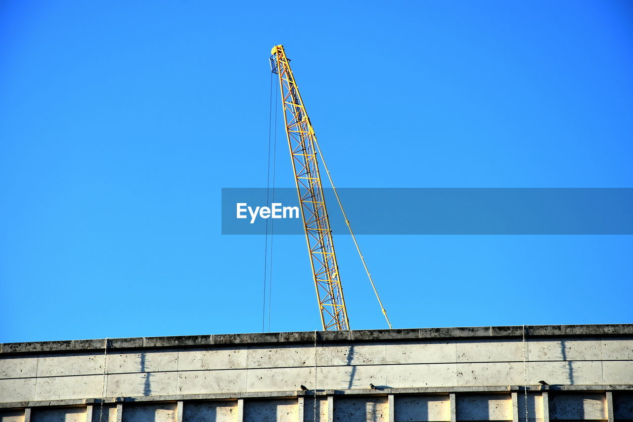 architecture, built structure, sky, blue, clear sky, low angle view, construction site, building exterior, crane - construction machinery, construction industry, no people, industry, machinery, day, nature, copy space, outdoors, sunny, landmark, city, development, building