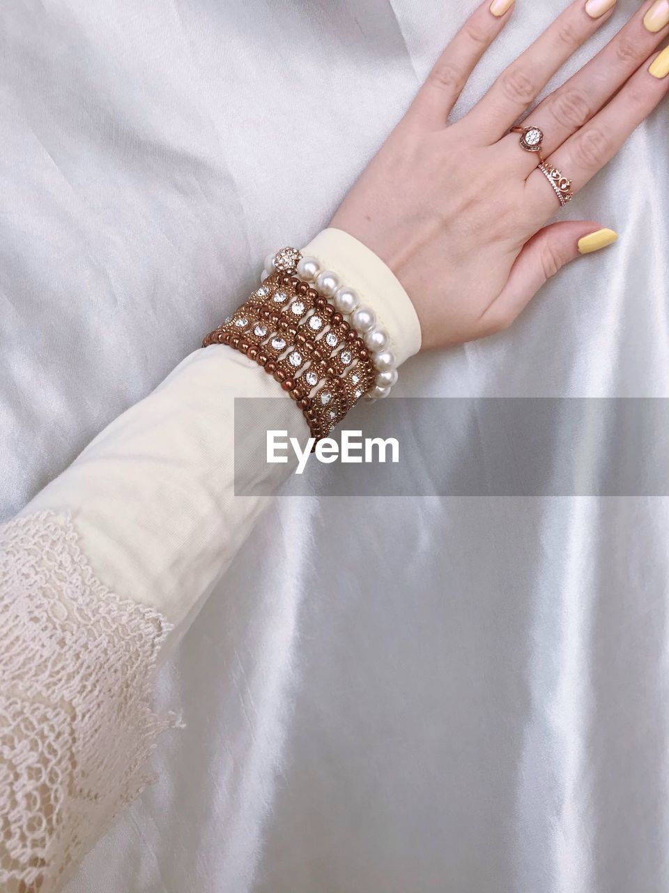 A hand of a woman wearing longsleeve and a bracelet