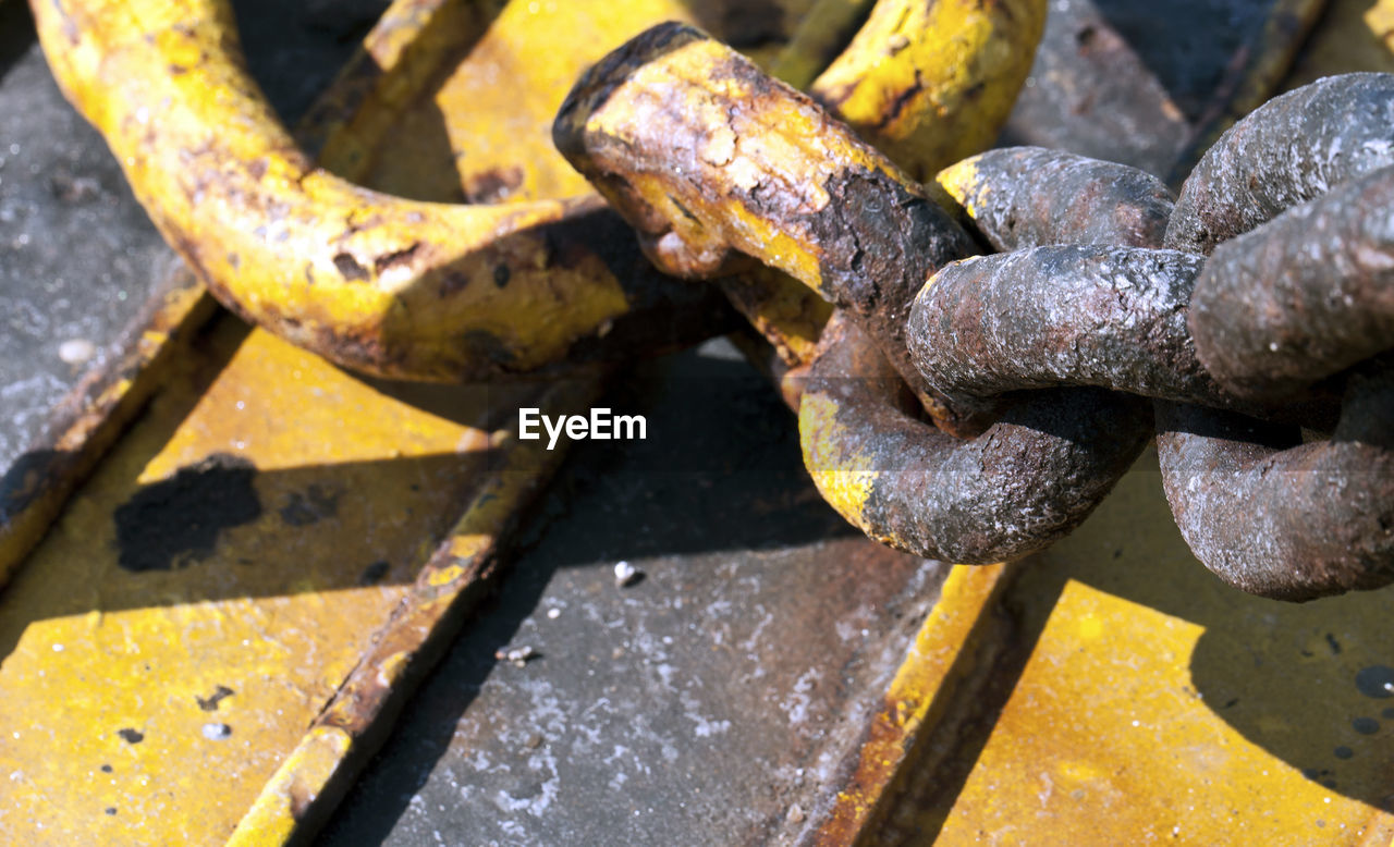 HIGH ANGLE VIEW OF RUSTY CHAIN