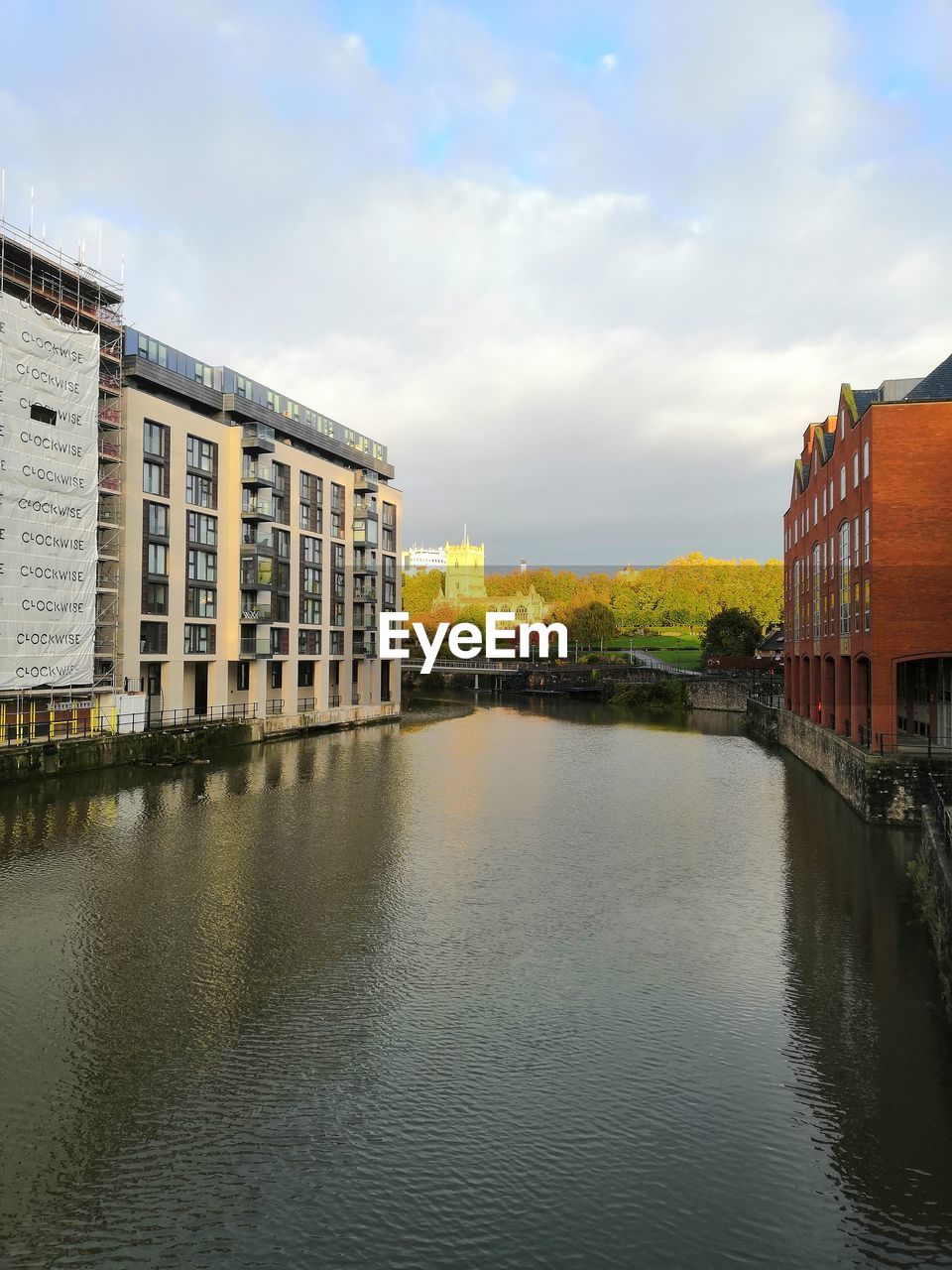 RIVER AMIDST BUILDINGS AGAINST SKY