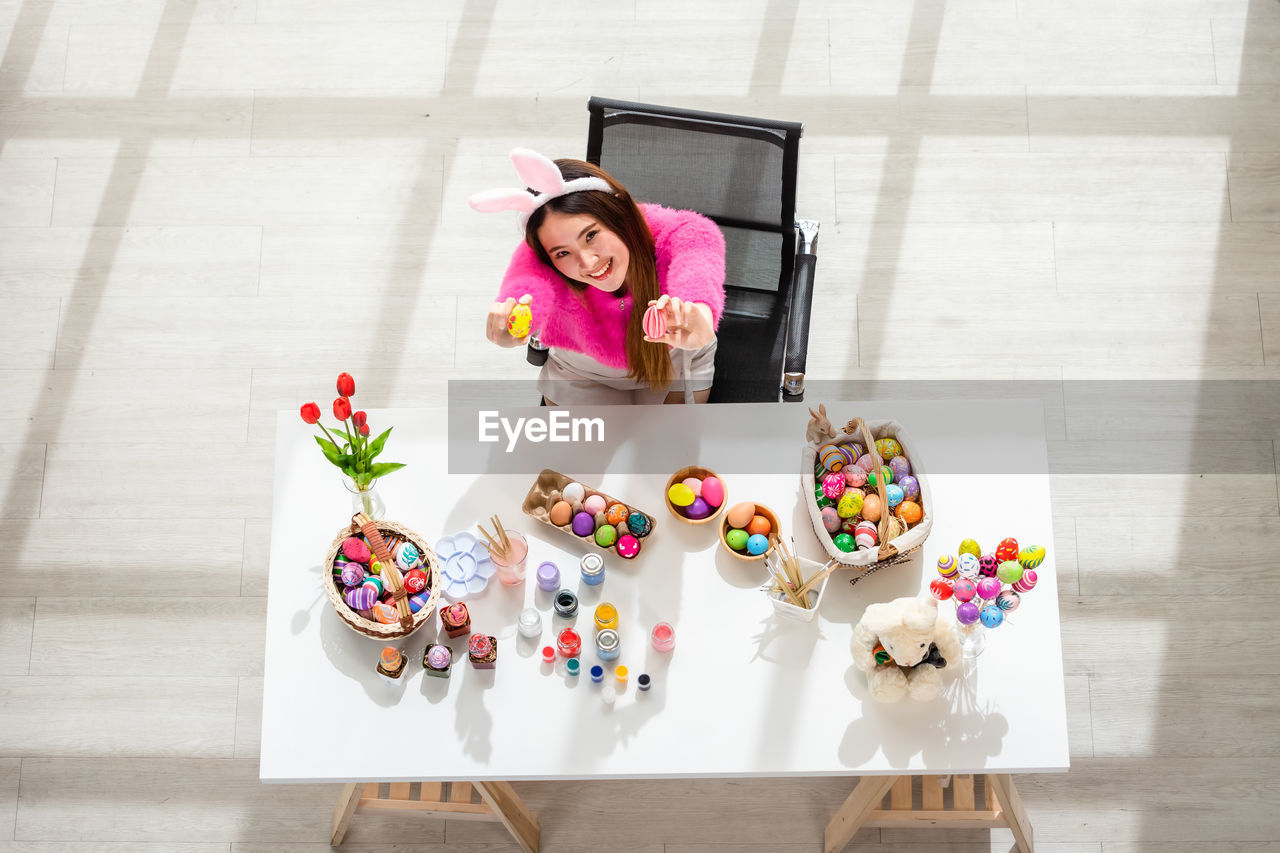 PORTRAIT OF A SMILING YOUNG WOMAN WITH STUFFED TOY