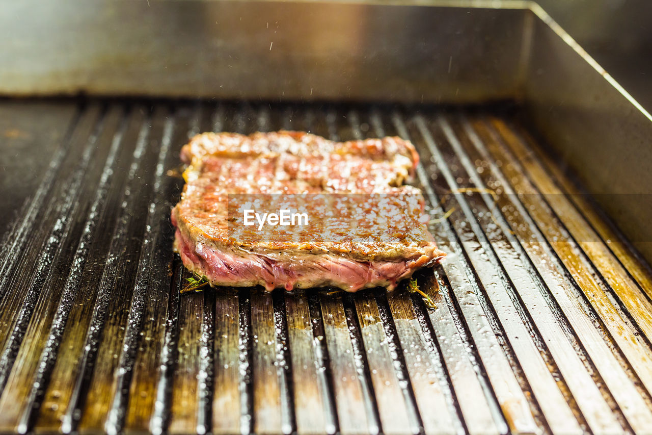 CLOSE-UP OF MEAT ON BARBEQUE GRILL