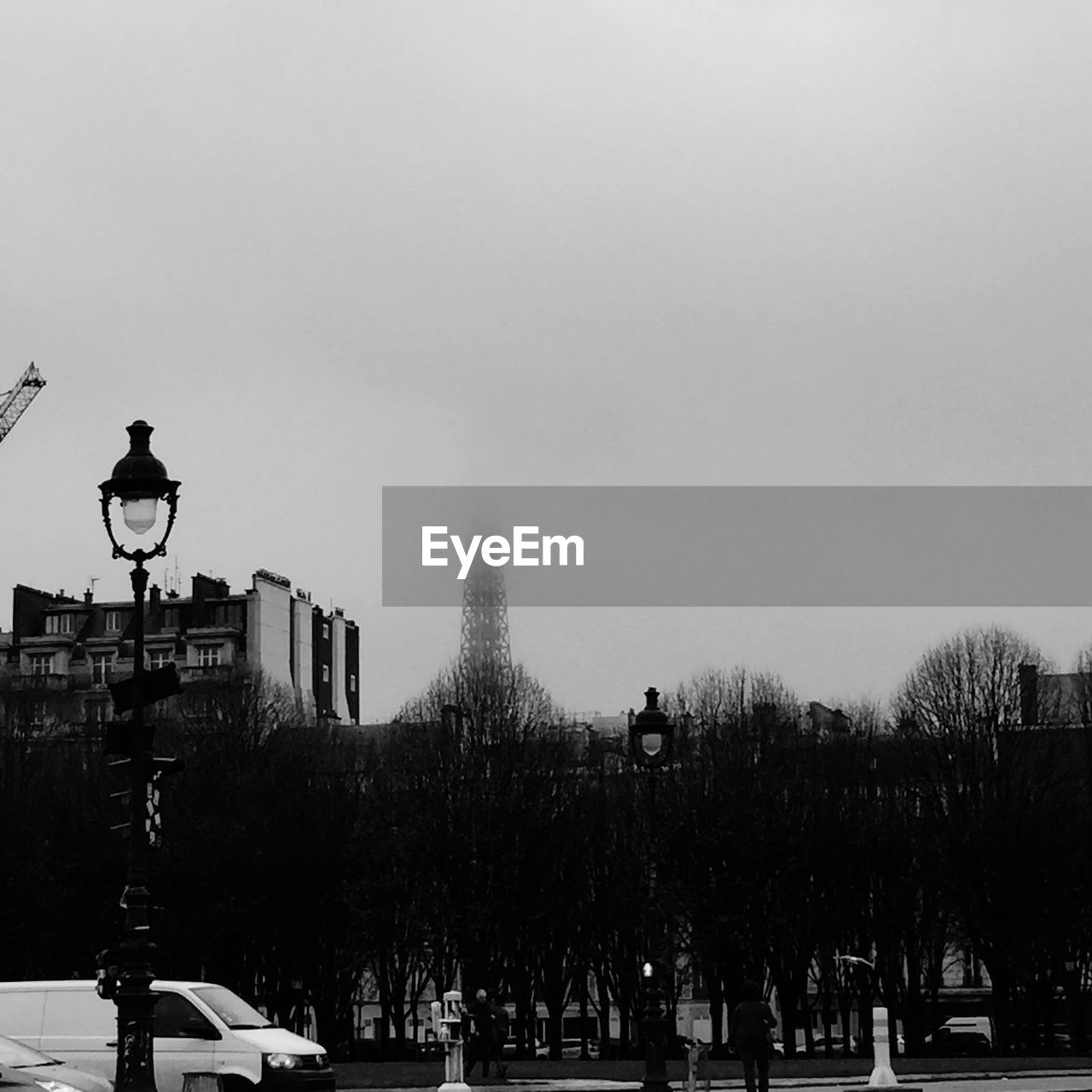 Van on road by eiffel tower during foggy weather