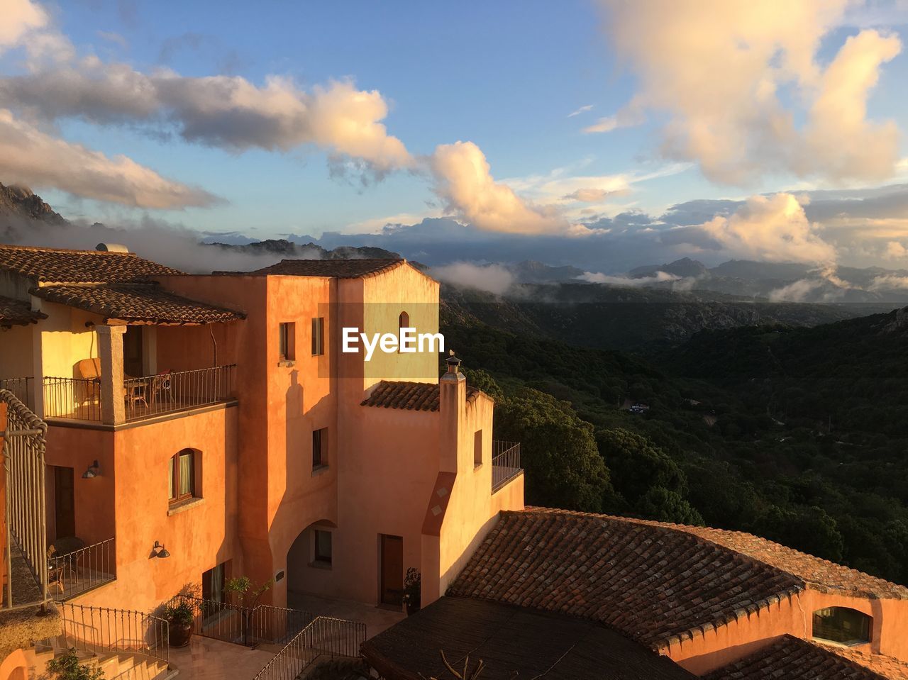 Exterior of houses in town against sky during sunset