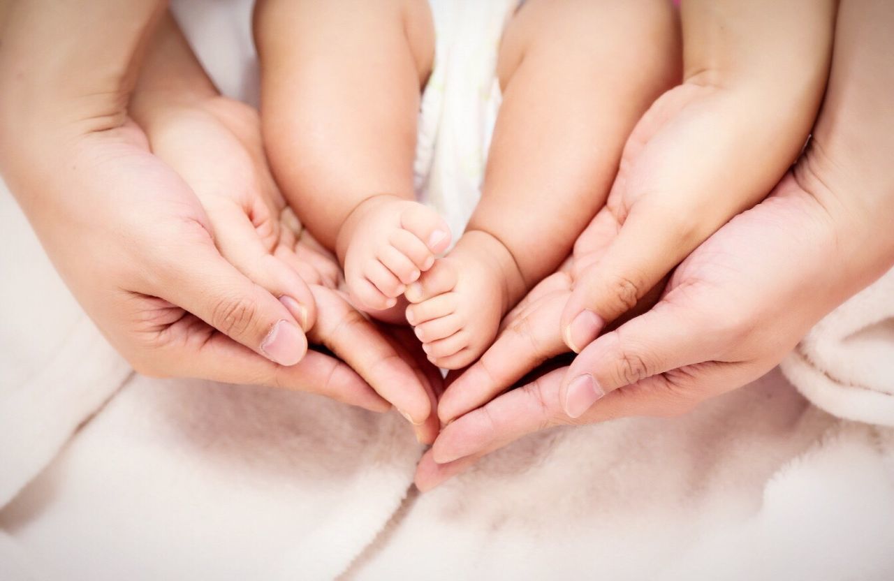 Extreme close up of hands holding baby feet