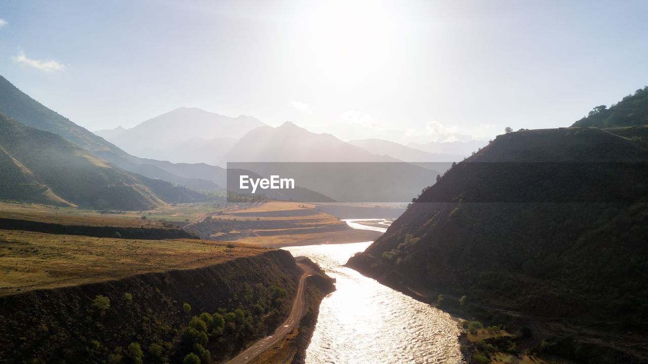 Scenic view of river amidst mountains against sky