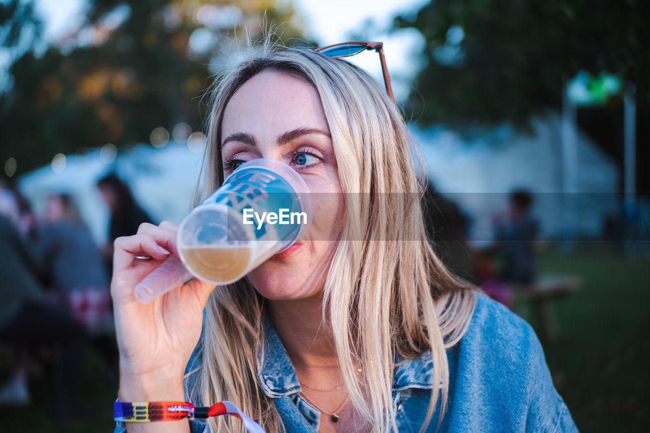Blond woman drinking craft beer at festival