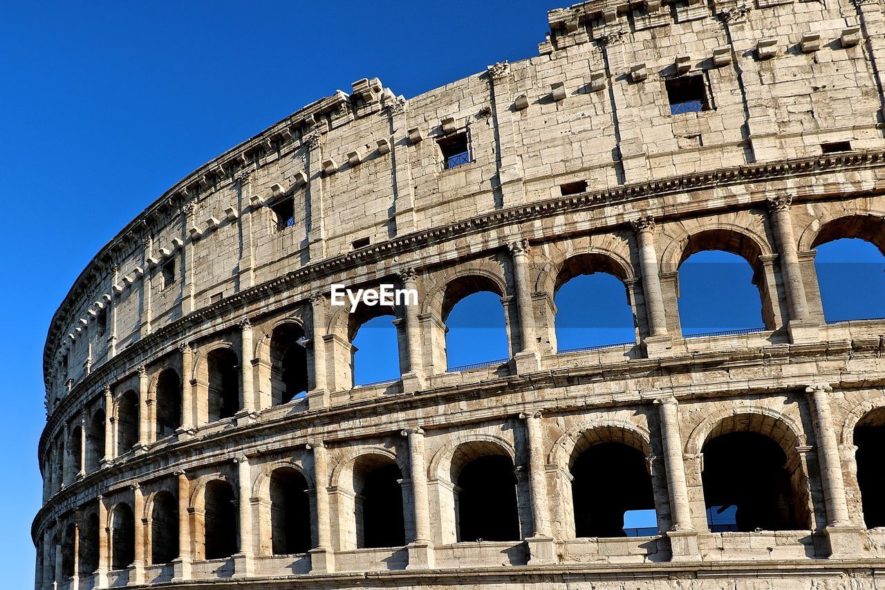 Low angle view of coliseum against clear sky