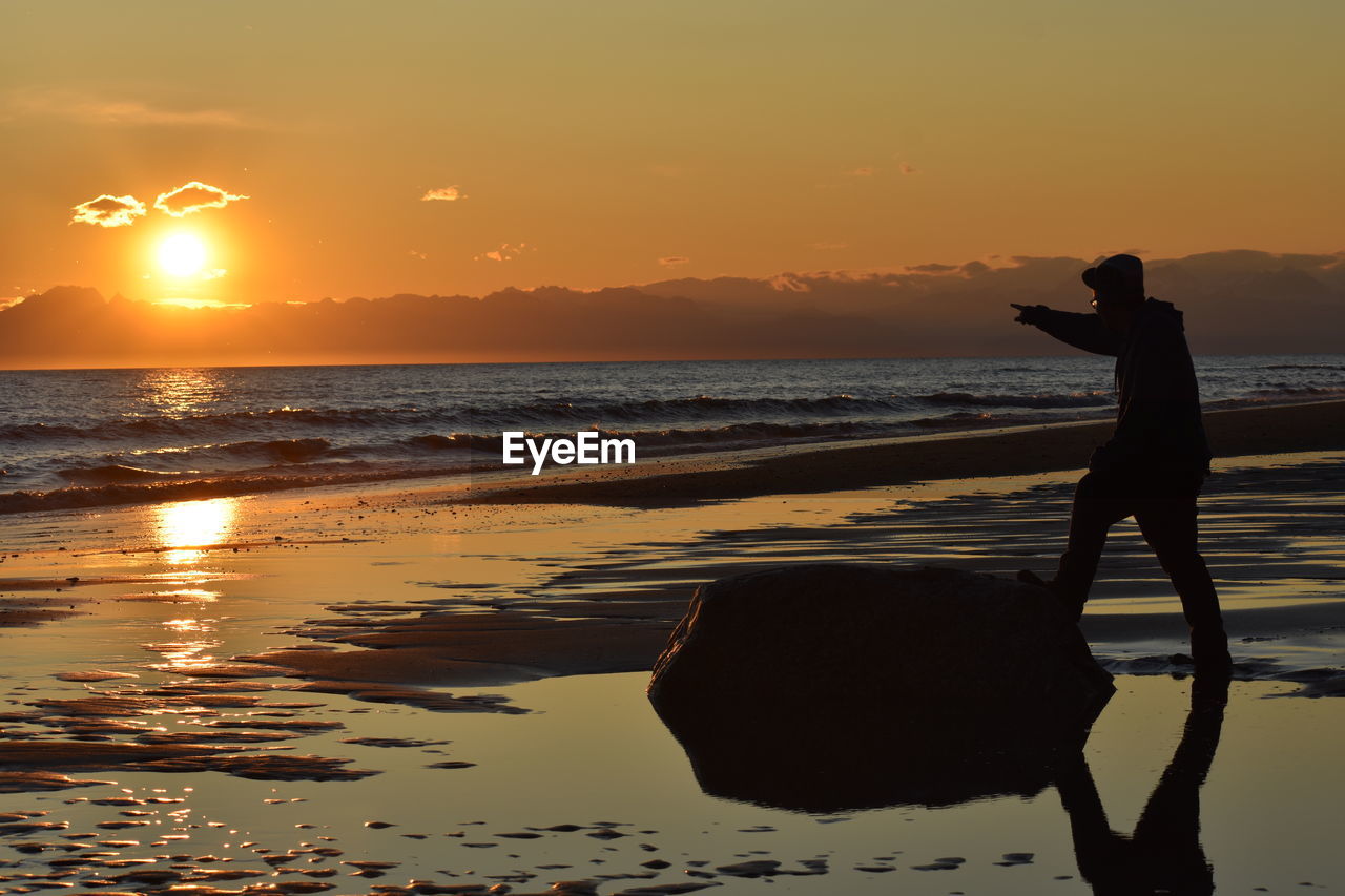SILHOUETTE MAN ON BEACH DURING SUNSET
