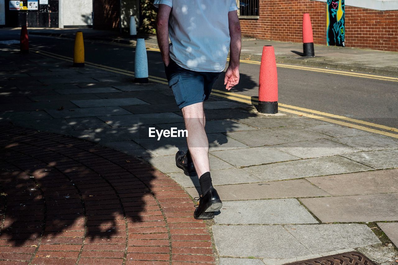 WOMAN WALKING ON SIDEWALK