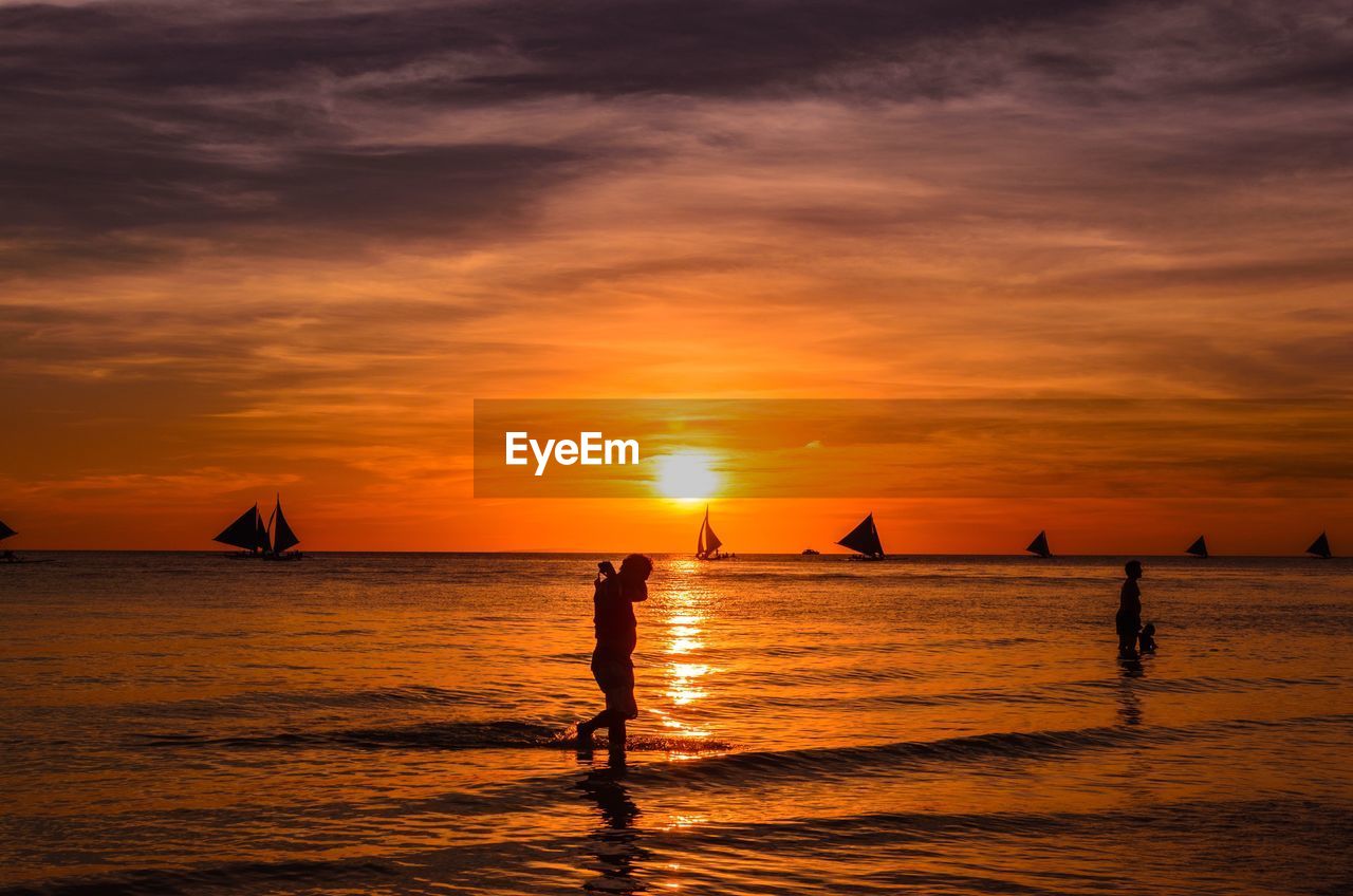 SILHOUETTE PEOPLE ON BEACH AT SUNSET