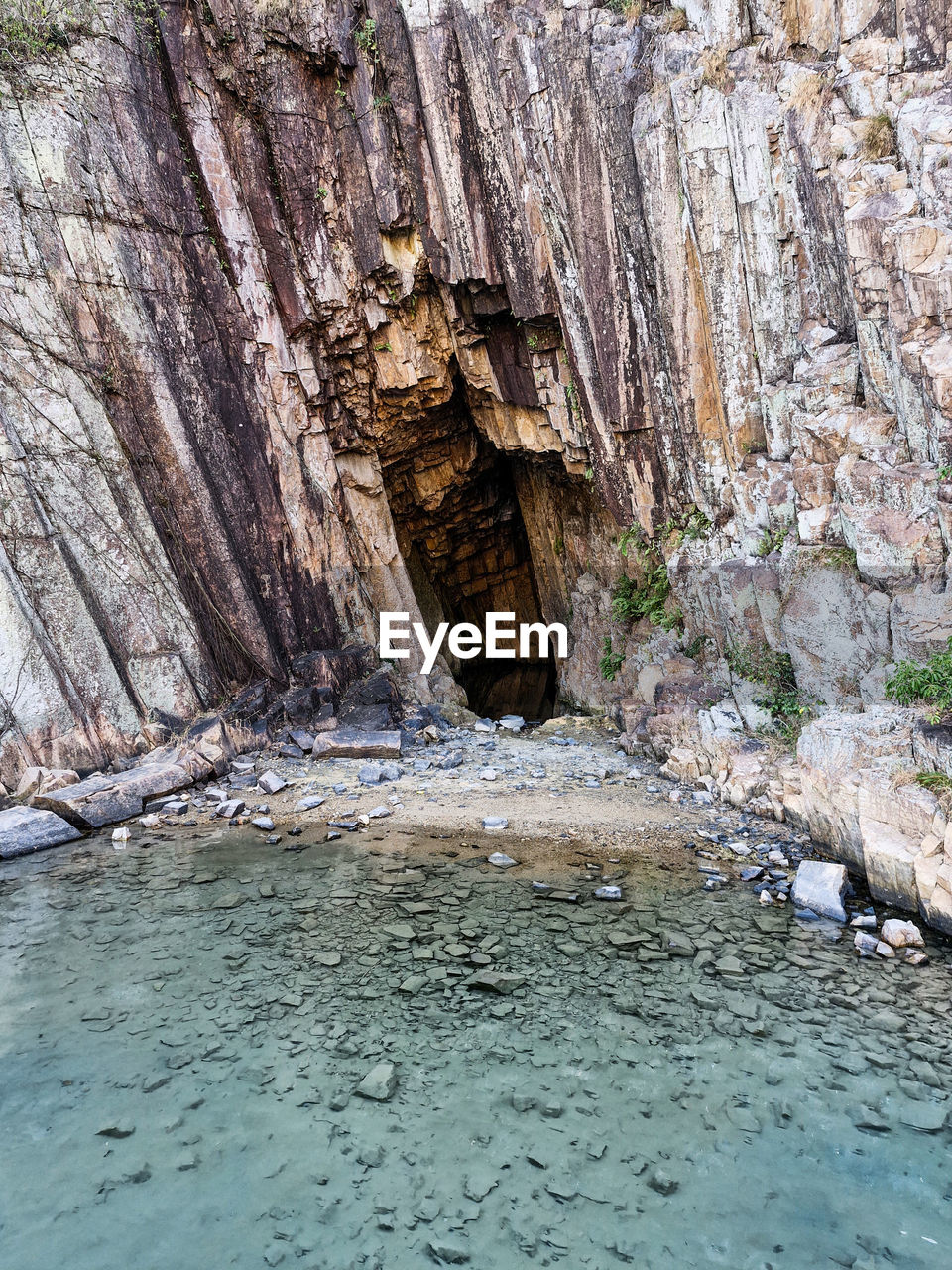 rock, water, rock formation, nature, cave, no people, wadi, cliff, beauty in nature, day, geology, non-urban scene, land, scenics - nature, tranquility, waterfront, sea cave, outdoors, terrain, formation, river, physical geography, travel destinations, eroded, tranquil scene, environment, architecture, canyon, mountain, tree, travel