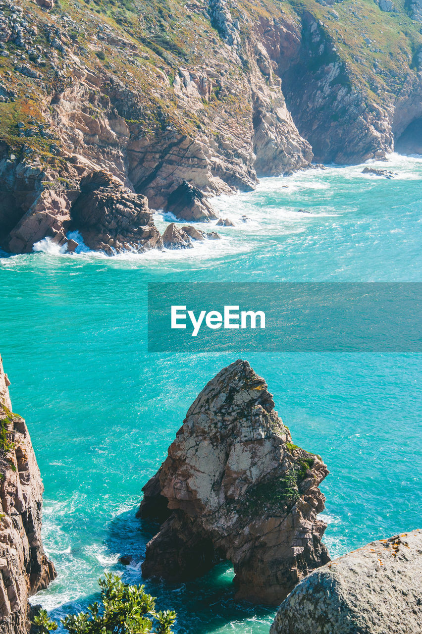 High angle view of rocks on sea shore