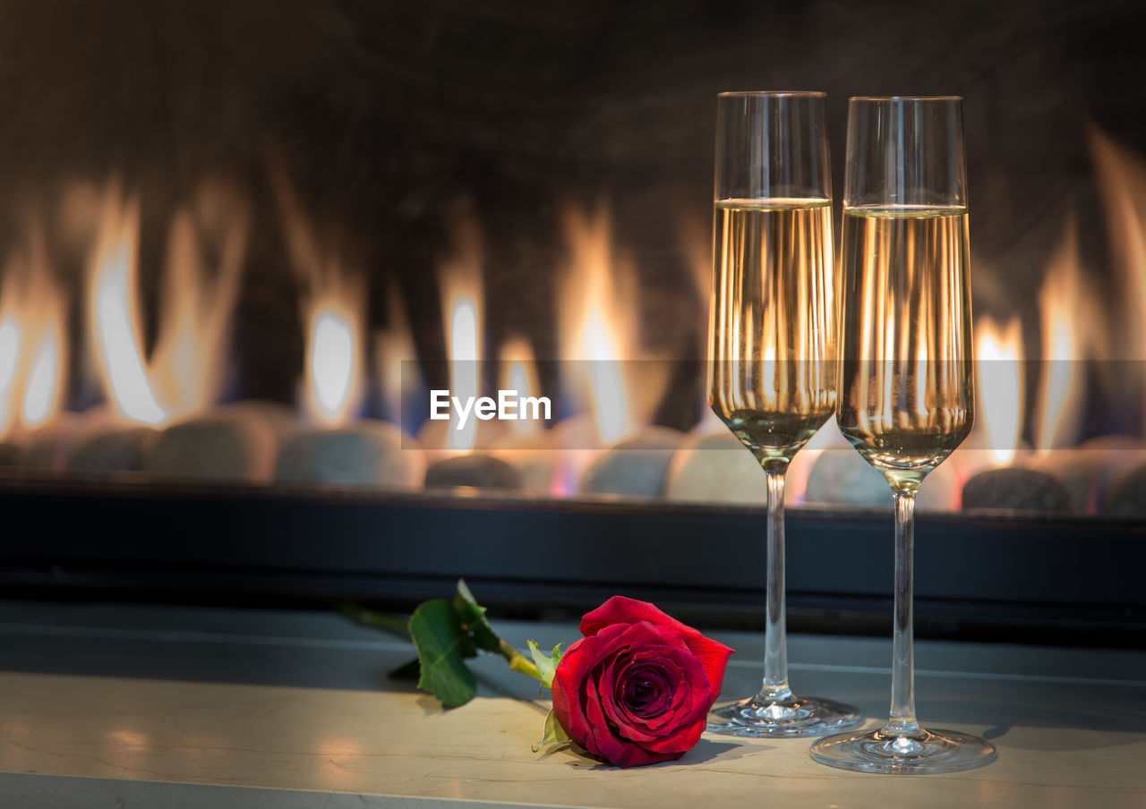 Champagne flutes with red rose on table