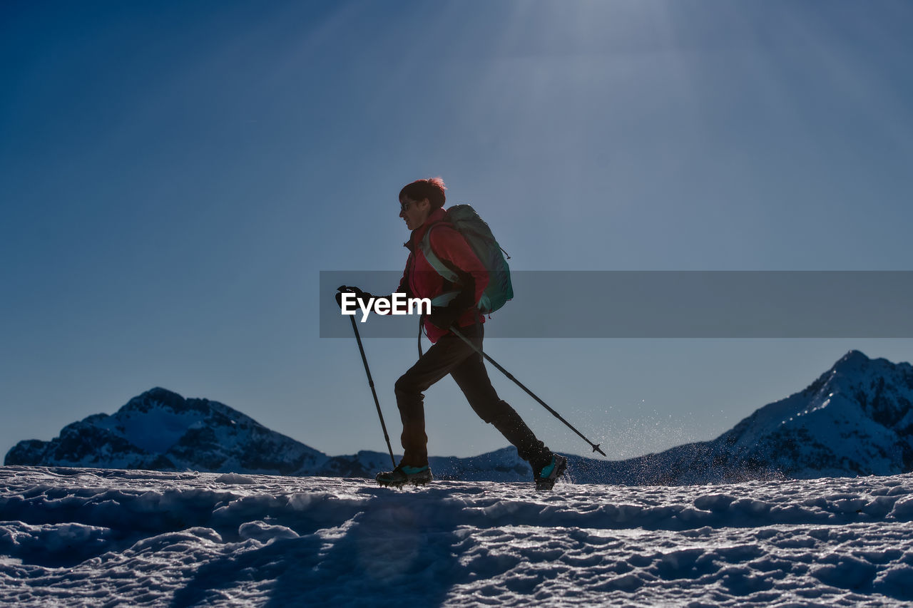 MAN ON SNOWCAPPED MOUNTAINS AGAINST SKY