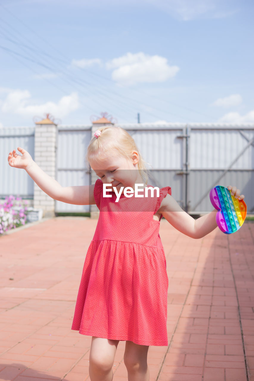 Cute girl with pink arms raised