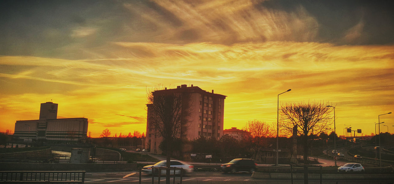 Cars on city street at sunset