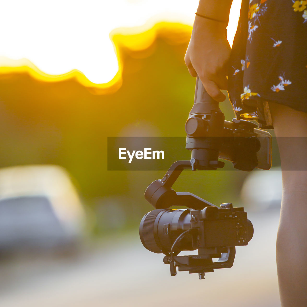 Close-up of camera hanging from car against sky