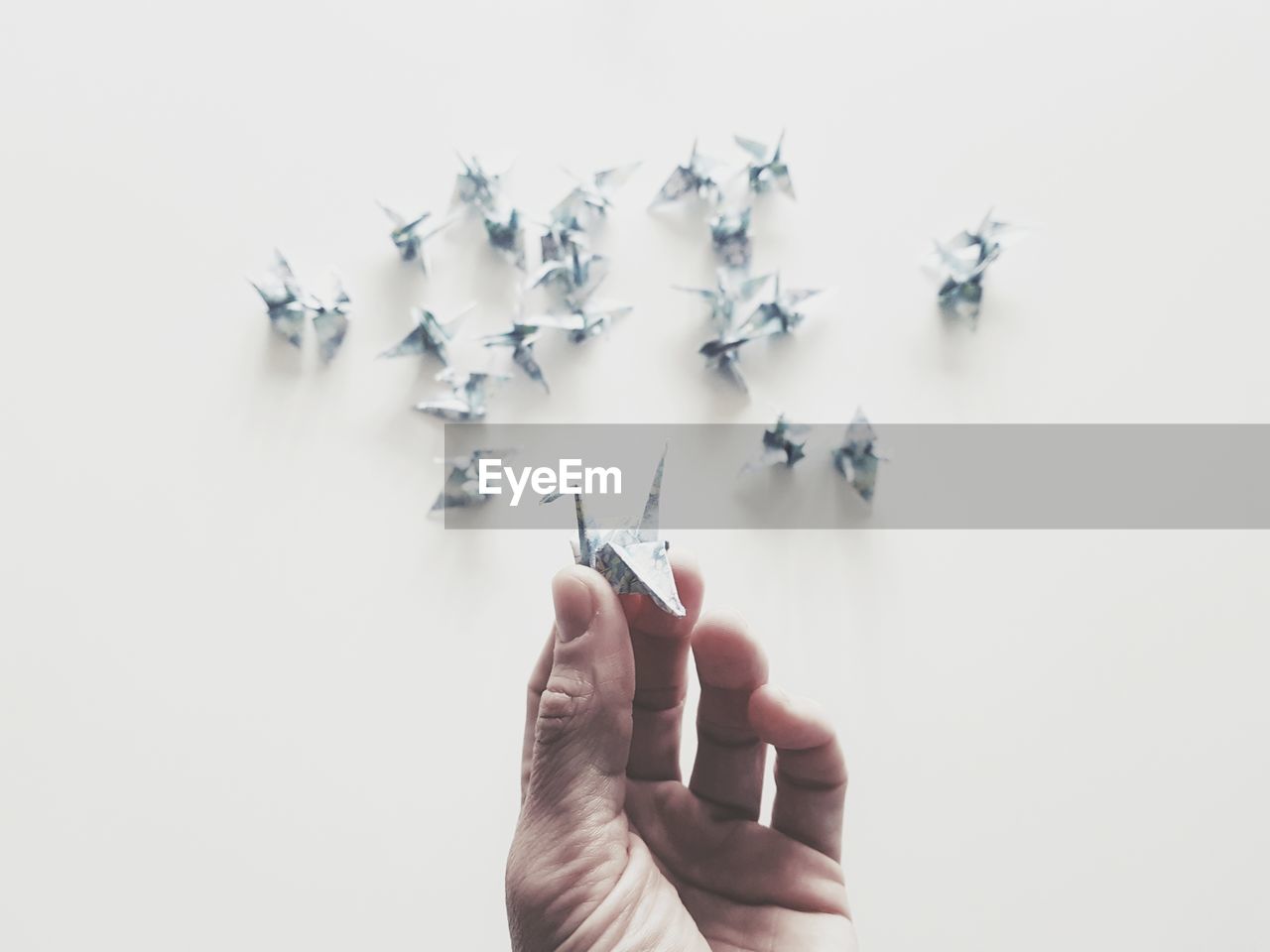 Cropped hands with origami on table