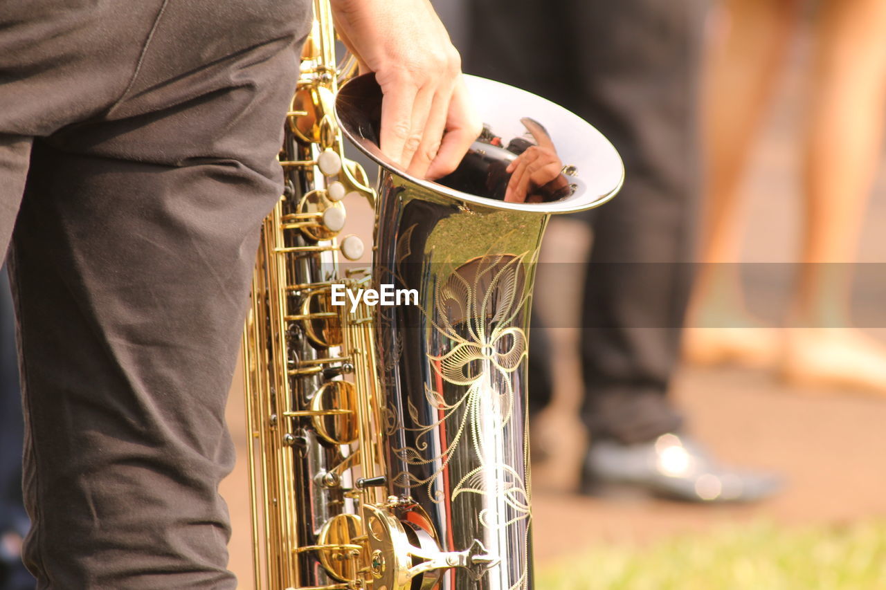 Cropped hand of person holding saxophone