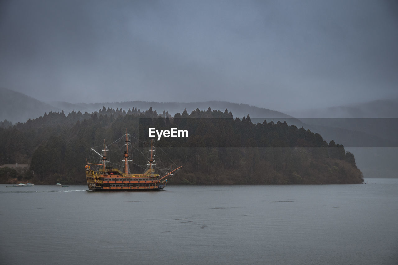 Ship sailing in sea against sky