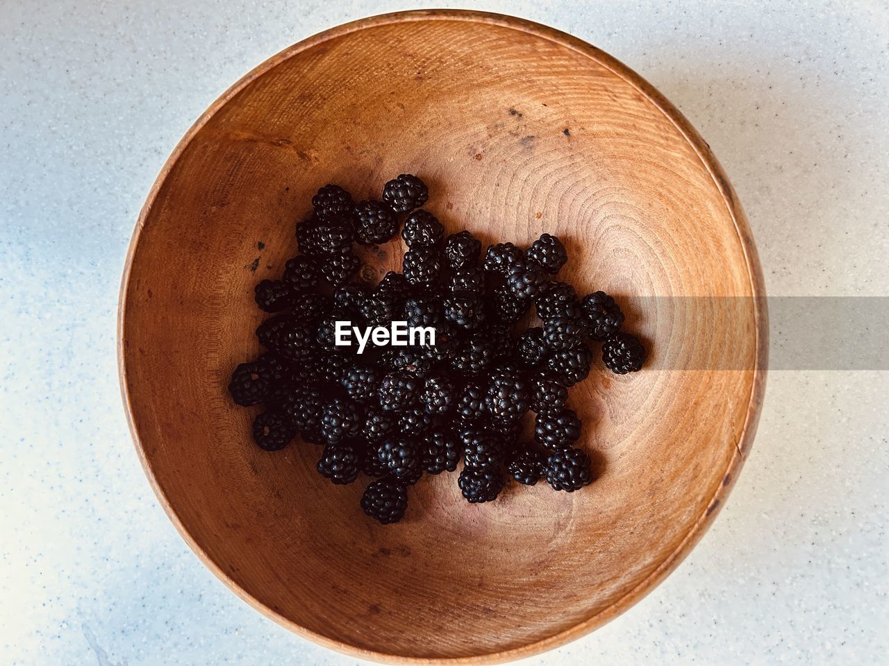 Blackberries in a grained wooden bowl. foraged, locally sourced, nutritious fruit.