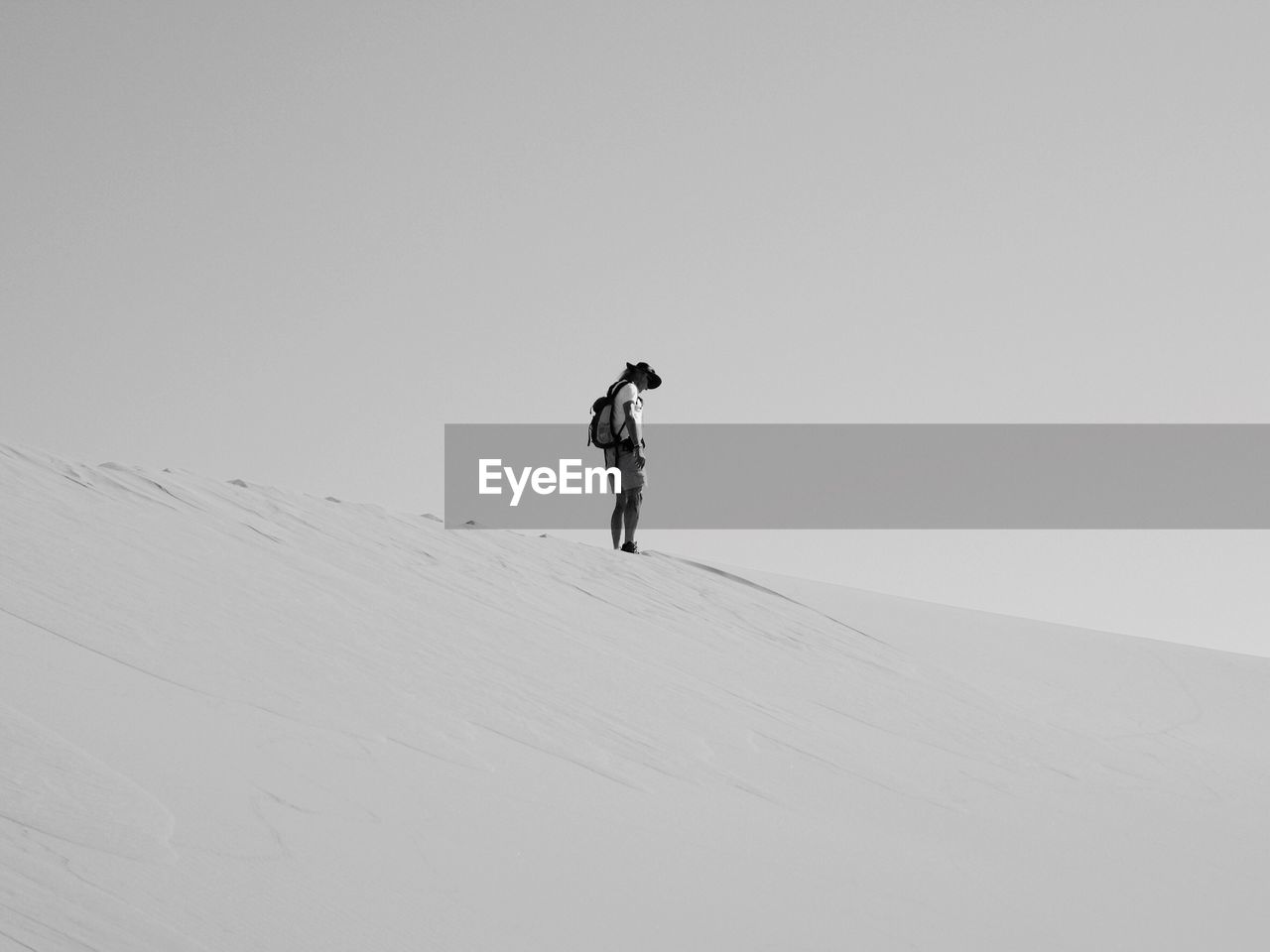 Full length of man standing on sand dune against sky
