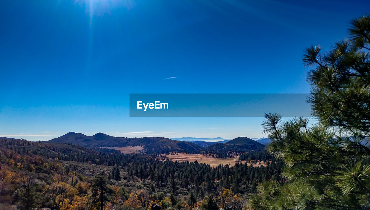 Scenic view of mountains against blue sky