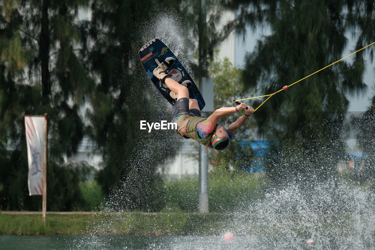 MAN PHOTOGRAPHING SPLASHING WATER ON PLANTS