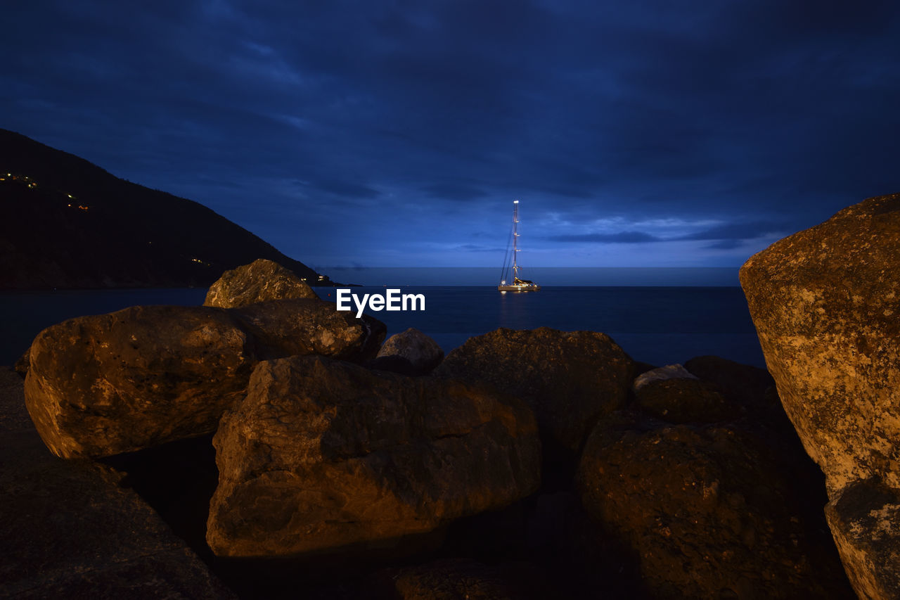 Suggestive view between the rocks of a boat at sea