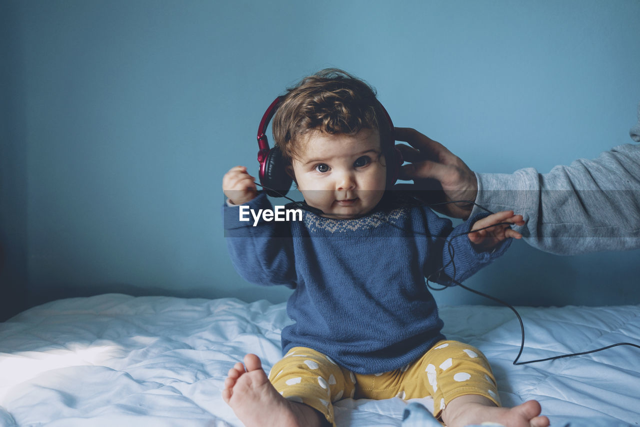 Cute girl playing with headphones at home
