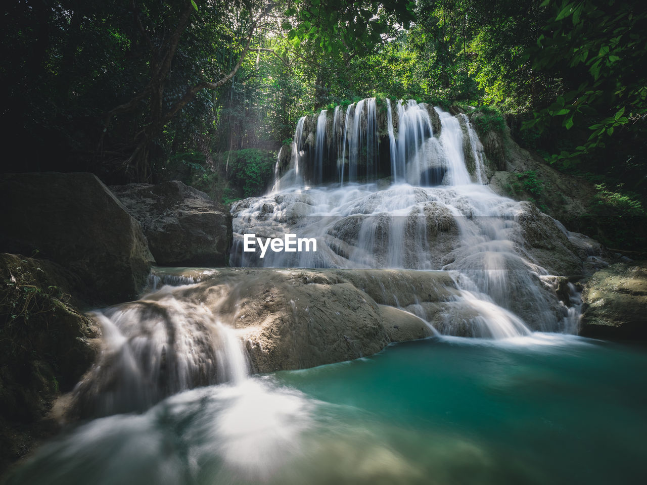 Scenic waterfall smooth stream, turquoise pond in rainforest. erawan falls, kanchanaburi, thailand.