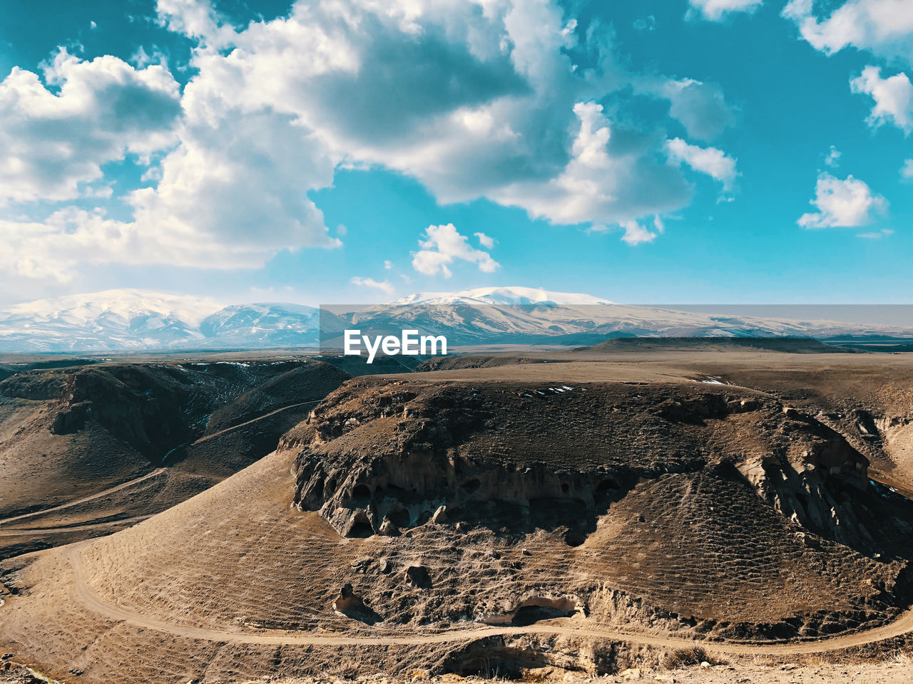 Aerial view of desert against cloudy sky