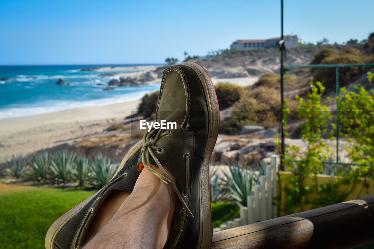 Close-up of man with feet up