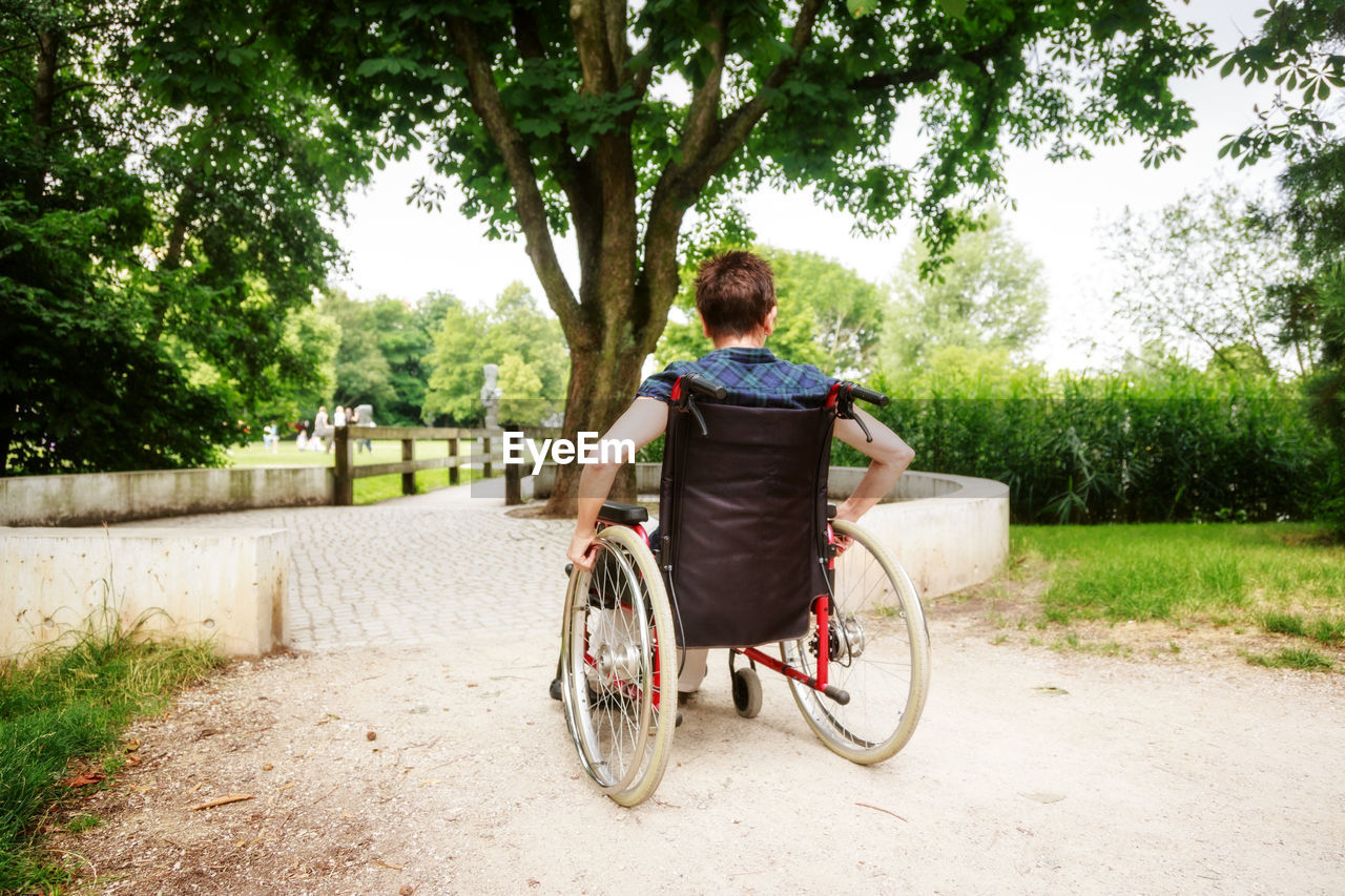 Woman sitting on wheelchair in public park